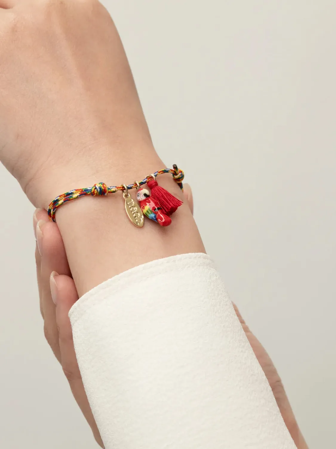 Nach Bijoux bracelet cordon perroquet rouge pompon ajustable
